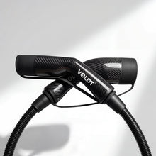 Stijlvol elektrisch laden met de lichtgewicht Voldt carbon fibre laadkabel bij een sportauto.